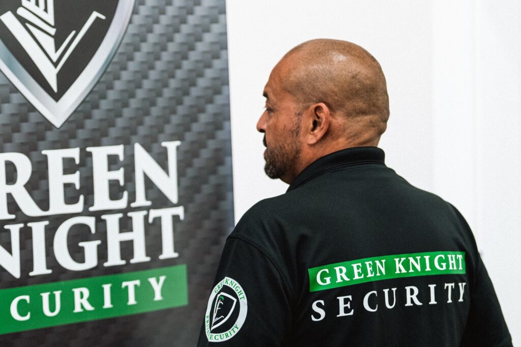 A retail security officer in California wearing a Green Knight Security uniform inside a retail security facility.